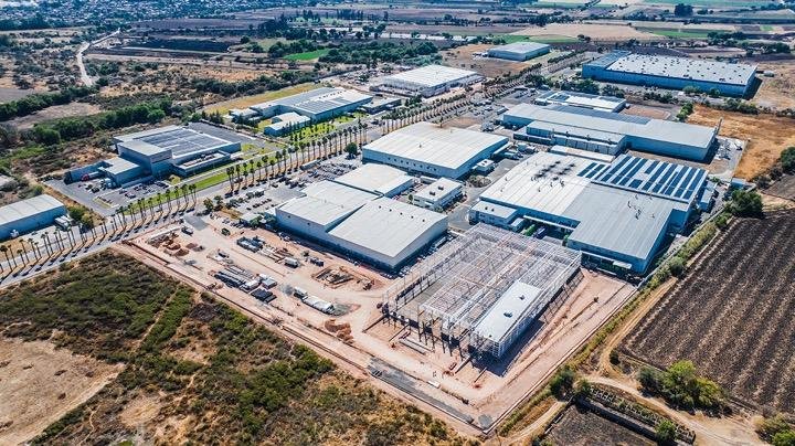 Vista aérea de un parque industrial en Michoacán con naves industriales, áreas en desarrollo e infraestructura logística para operaciones industriales y comerciales.